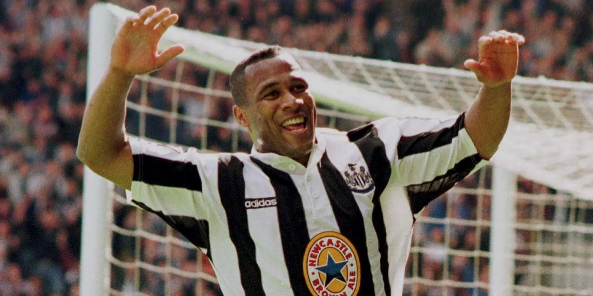 Les Ferdinand, tiền đạo mạnh mẽ, đang ăn mừng bàn thắng, thể hiện khả năng không chiến và dứt điểm uy lực.